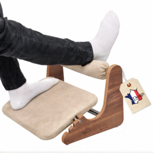 Ergonomic wooden footrest with beige microfibre suede cushion and adjustable ankle support for office desk.
